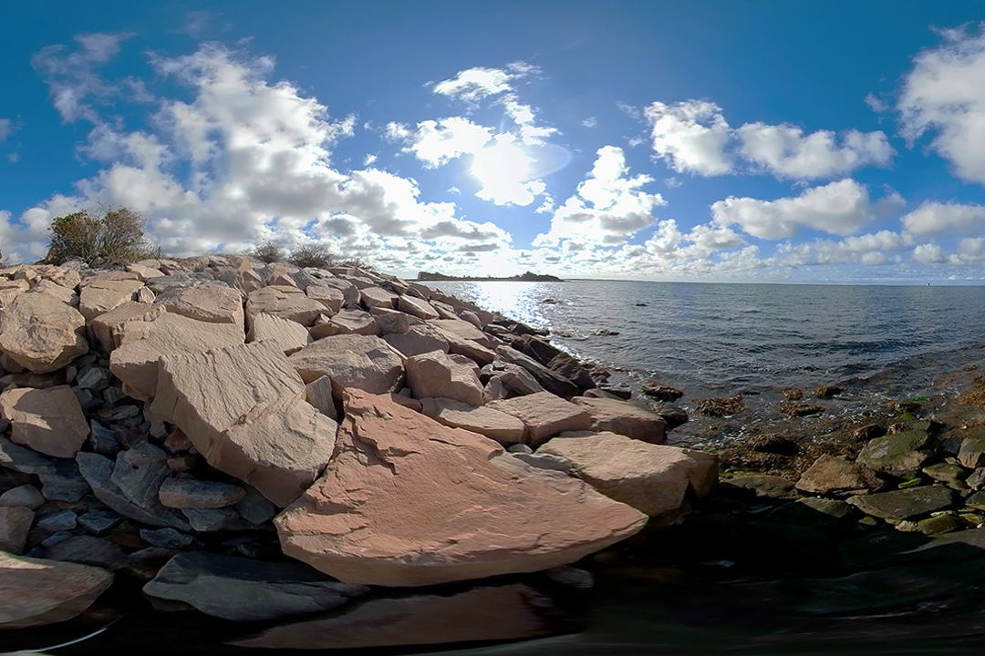 A rocky shoreline looks out to the Long Island Sound.